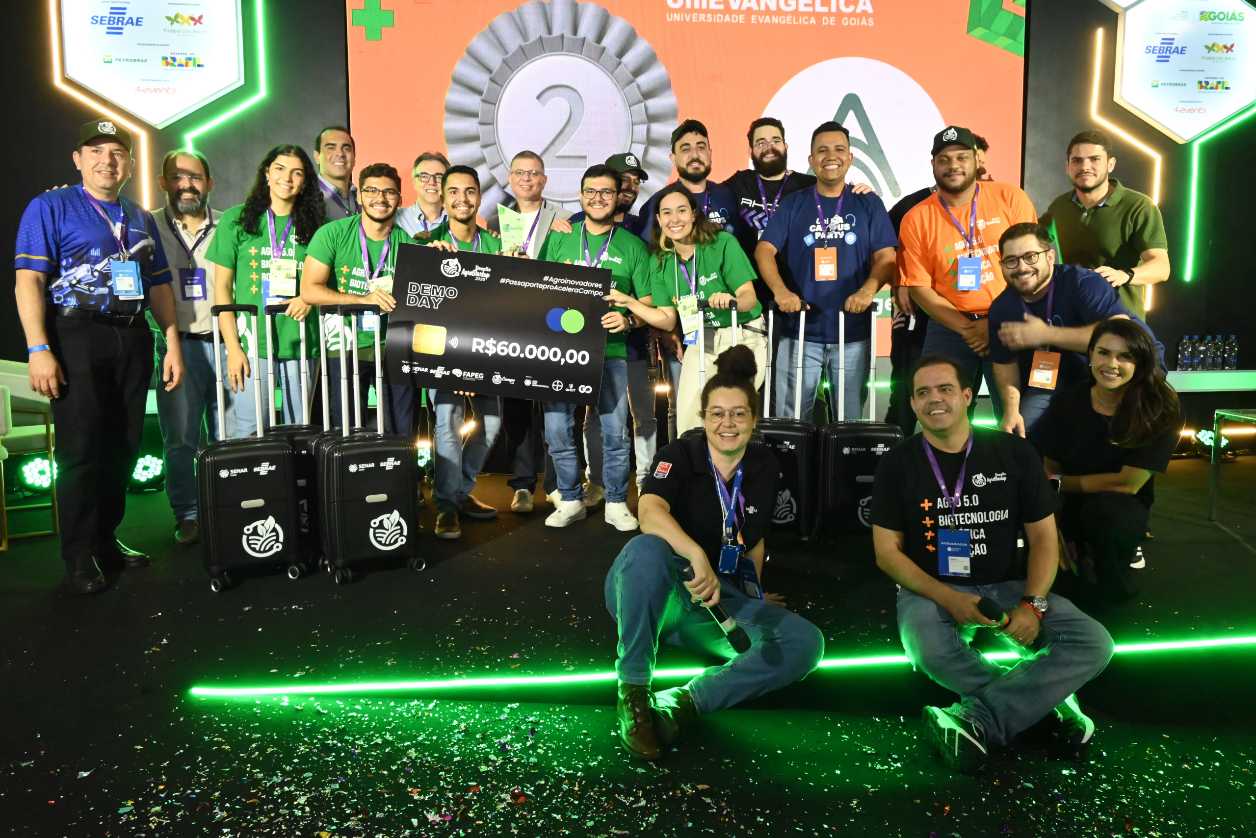 Equipe AcomGest no palco da Campus Party Goiás 2025 com o cheque de R$60.000